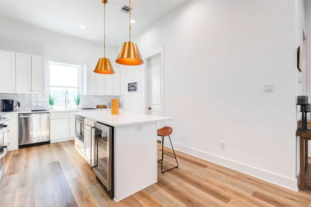 a kitchen with a sink cabinets stainless steel appliances and a window