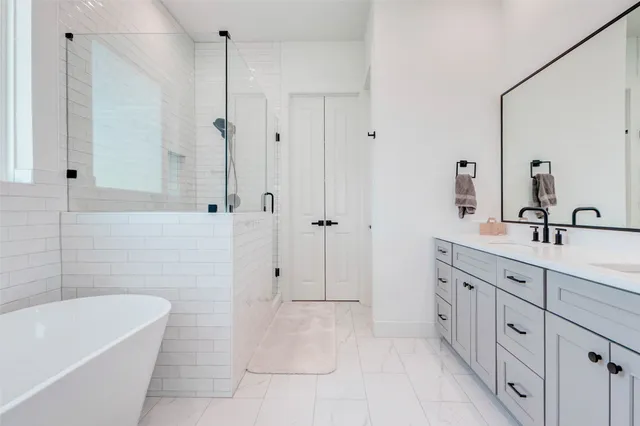 a spacious bathroom with a tub sink and mirror
