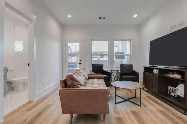 a living room with furniture a flat screen tv and a window