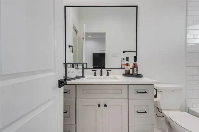 a bathroom with a sink vanity toilet and mirror