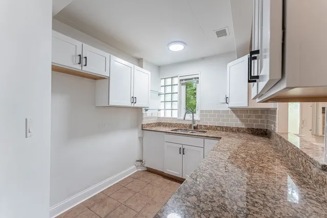 a kitchen with granite countertop a sink and cabinets