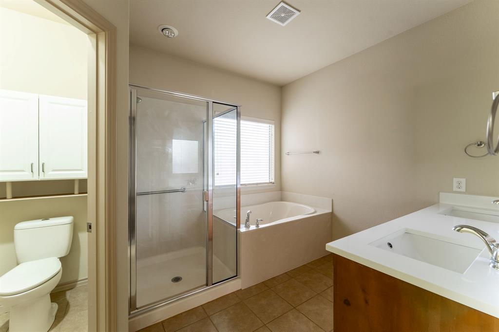 11156 Hawks Landing Road Fort Worth, TX 76052 - Photo 20 of 30 Carpeted interior space with a ceiling fan, a window with horizontal blinds, and an arched doorway leading to a bathroom with tile flooring