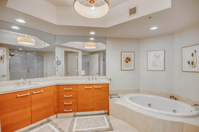 a bathroom with a tub a sink and mirror