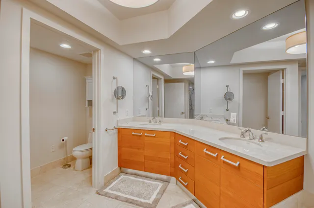 a spacious bathroom with a tub sink mirror and toilet