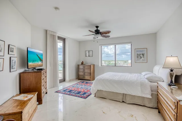 a bedroom with a bed a chandelier and a dresser
