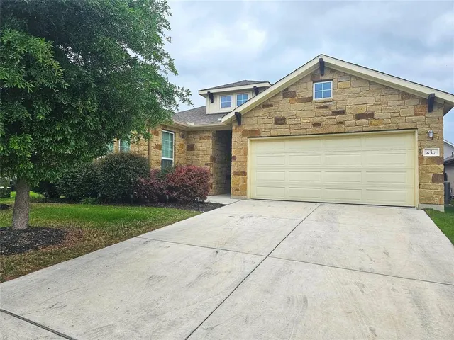 a front view of a house with a yard and garage
