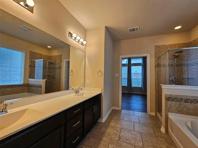 a bathroom with a tub sink and mirror