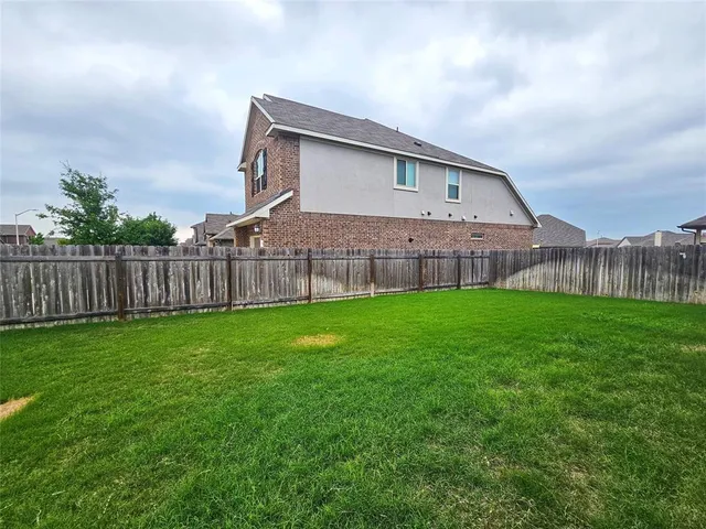 a front view of a house with garden space and barbeque oven