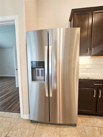 a metallic refrigerator freezer sitting in a kitchen