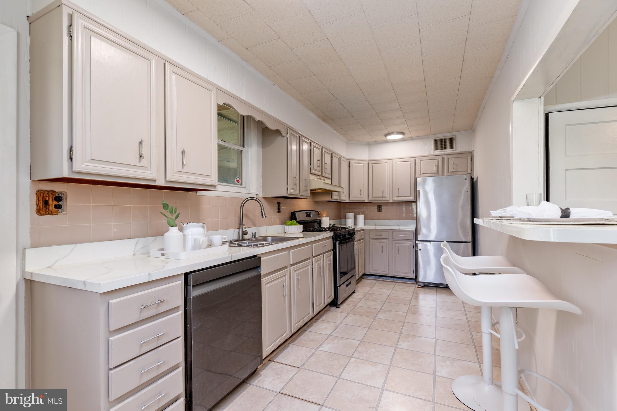 6426 Sherwood Road Baltimore, MD 21239 - Photo 12 of 43 a kitchen with a sink cabinets and stainless steel appliances