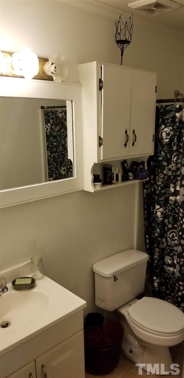 7512 Stuart Drive Raleigh, NC 27615 - Photo 8 of 9 a bathroom with a toilet a sink and a mirror