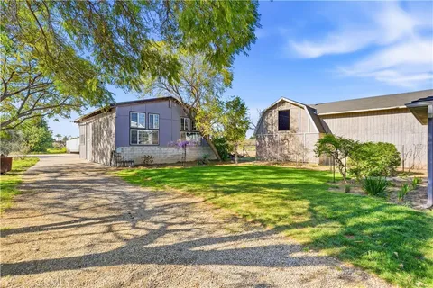 a view of a house with backyard and trees