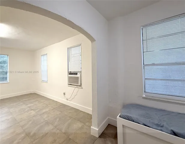 a kitchen with granite countertop white cabinets and refrigerator