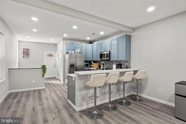 a kitchen with stainless steel appliances granite countertop a refrigerator a sink dishwasher and a stove with wooden floor