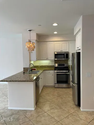 a kitchen with stainless steel appliances granite countertop a sink and a stove