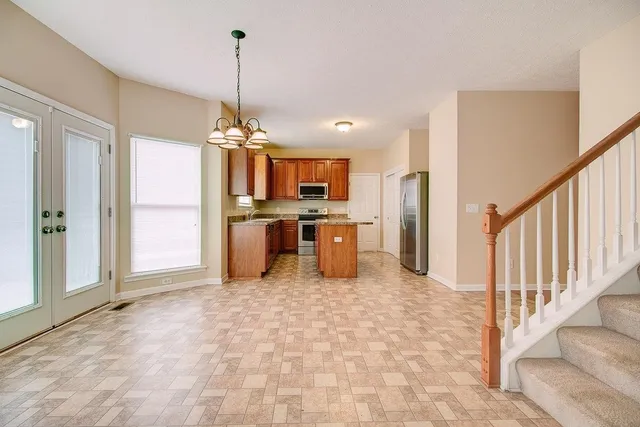 a view of a livingroom with a chandelier fan and windows