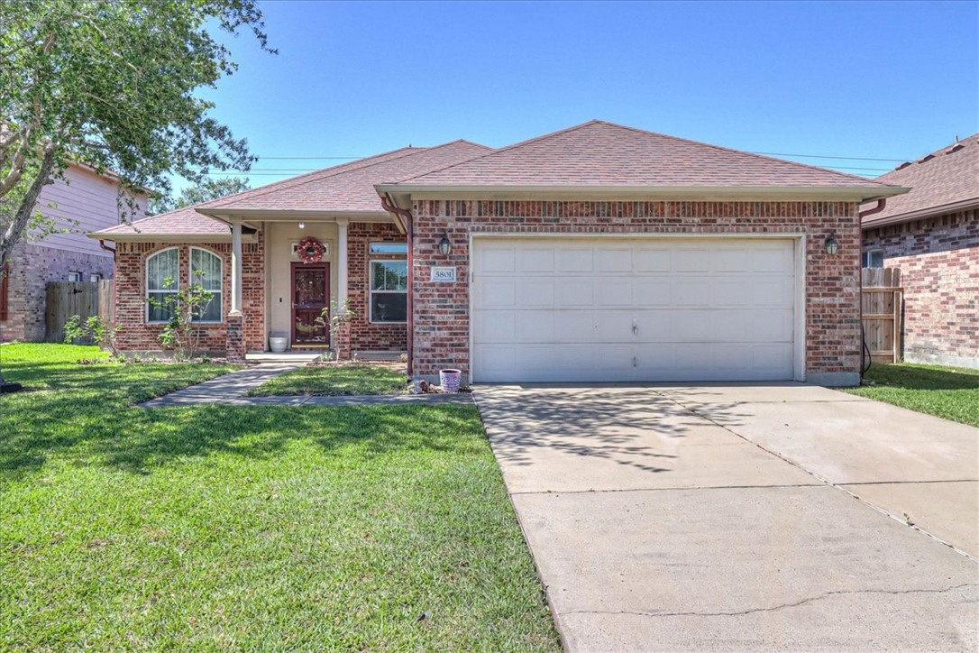 a front view of a house with a garden and yard