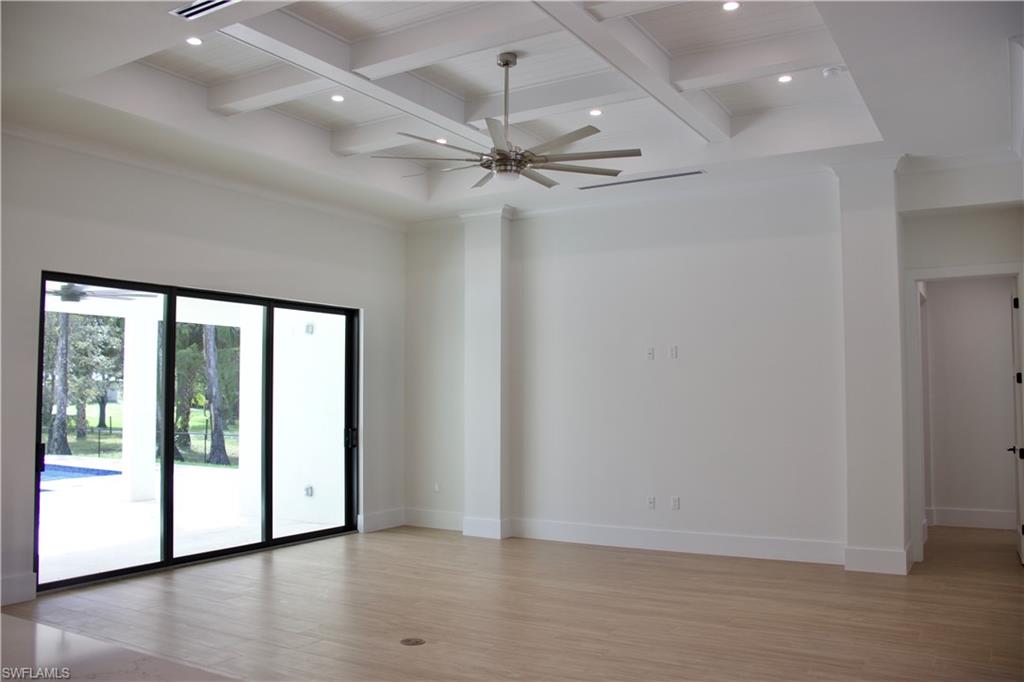 428 21st Street Southwest Naples, FL 34117 - Photo 16 of 45 an empty room with wooden floor fan and windows