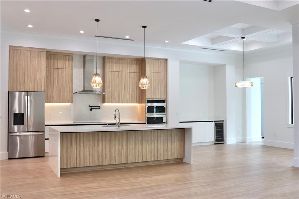 428 21st Street Southwest Naples, FL 34117 - Photo 18 of 45 a large kitchen with stainless steel appliances granite countertop a large counter top a sink cabinets and wooden floor