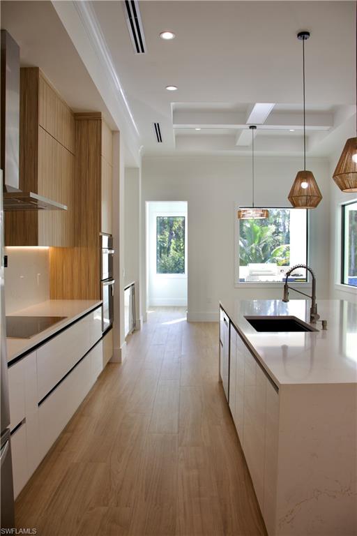 428 21st Street Southwest Naples, FL 34117 - Photo 19 of 45 a kitchen with stainless steel appliances granite countertop a sink a stove and a wooden floors
