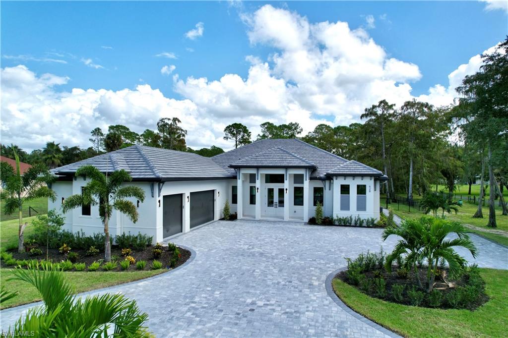 428 21st Street Southwest Naples, FL 34117 - Photo 2 of 45 a front view of a house with a yard
