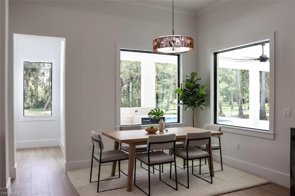 428 21st Street Southwest Naples, FL 34117 - Photo 23 of 45 a dining room with furniture a chandelier and wooden floor