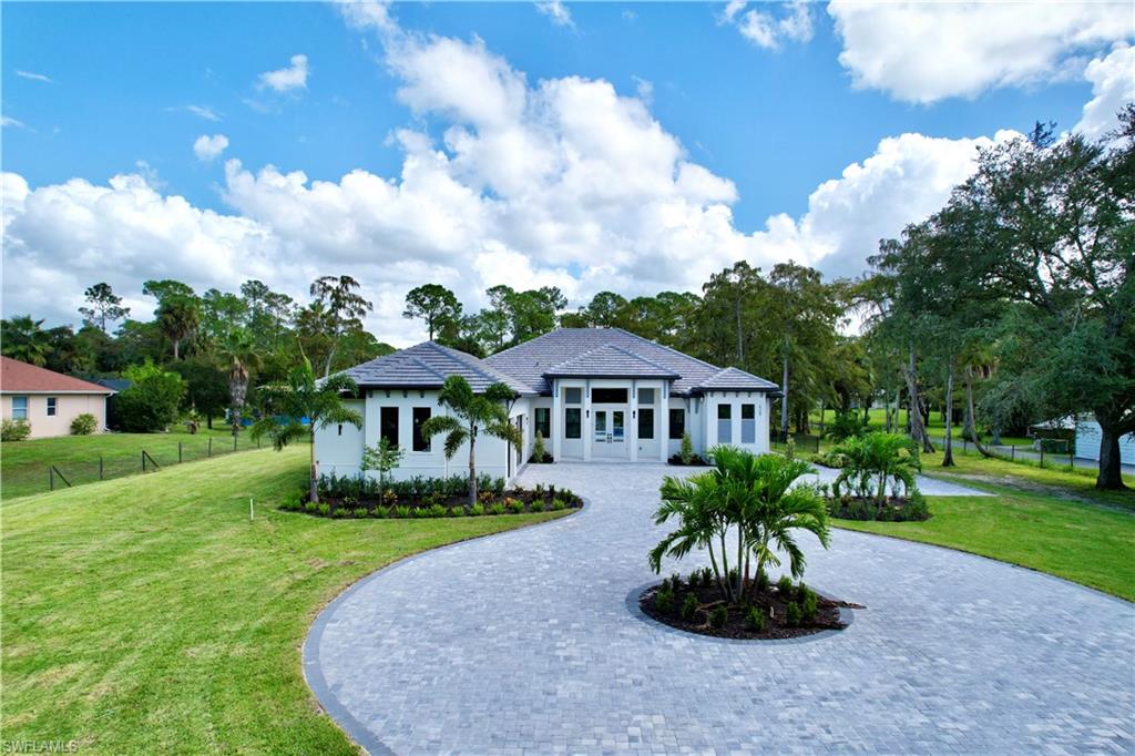 428 21st Street Southwest Naples, FL 34117 - Photo 4 of 45 a front view of a house with a garden