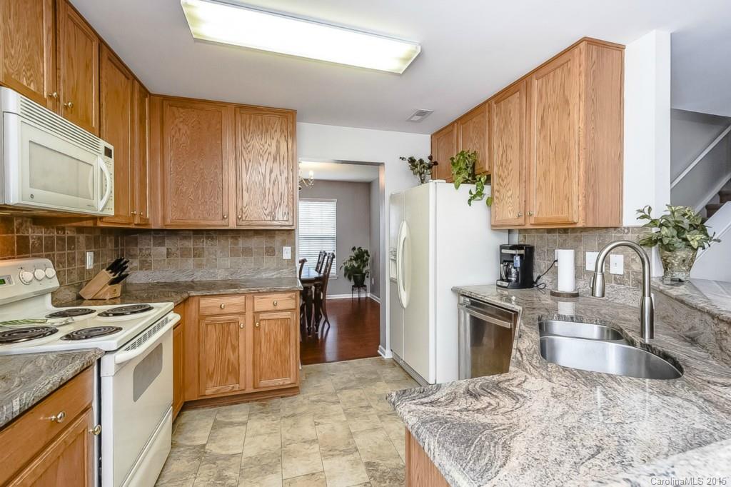 7475 Fallen Timber Lane Tega Cay, SC 29708 - Photo 9 of 24 a kitchen with stainless steel appliances granite countertop a sink stove refrigerator and cabinets