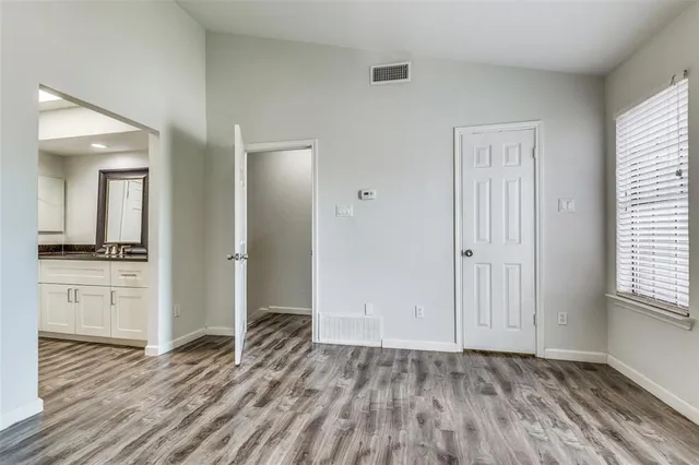 a view of a room with wooden floor and a window