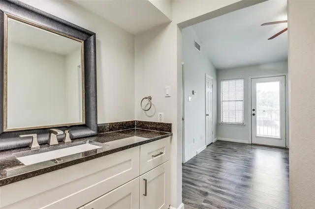 a bathroom with a granite countertop sink and a mirror