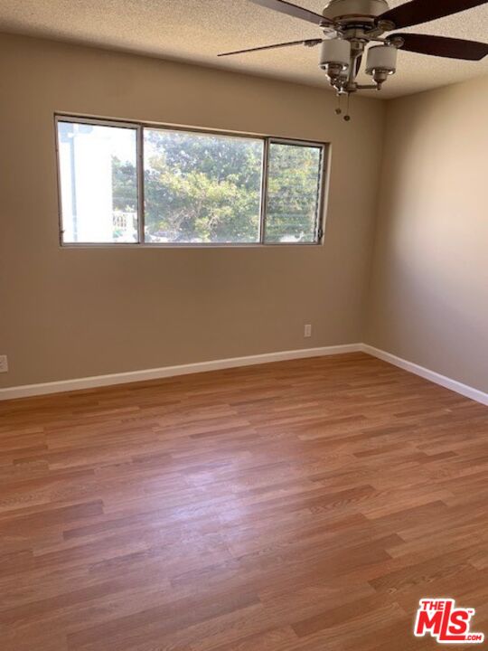 1201 South Sherbourne Drive, Unit 4 Los Angeles, CA 90035 - Photo 12 of 14 a view of an empty room with wooden floor and a window