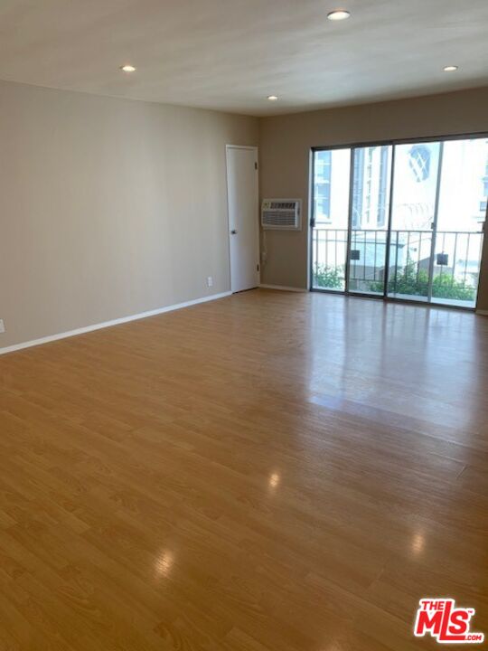 1201 South Sherbourne Drive, Unit 4 Los Angeles, CA 90035 - Photo 2 of 14 a view of an empty room with a window and wooden floor