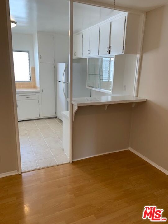 1201 South Sherbourne Drive, Unit 4 Los Angeles, CA 90035 - Photo 4 of 14 an empty room with wooden floor and cabinet