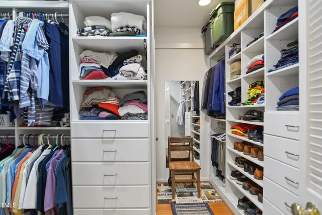 a view of walk in closet with clothes and shoes