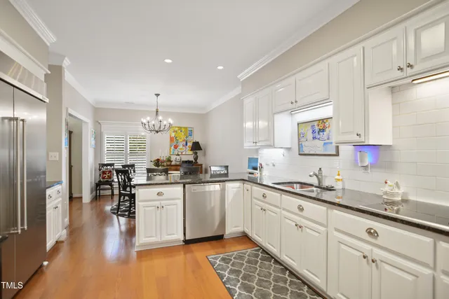 a kitchen with granite countertop a sink stainless steel appliances and cabinets
