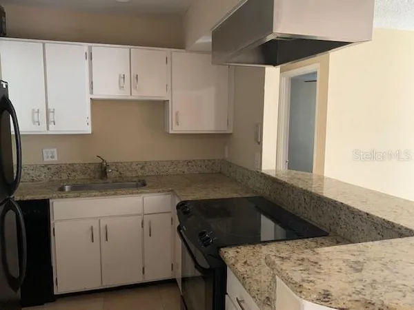 a kitchen with a sink dishwasher and white cabinets