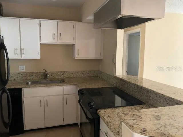 a kitchen with a sink dishwasher and white cabinets