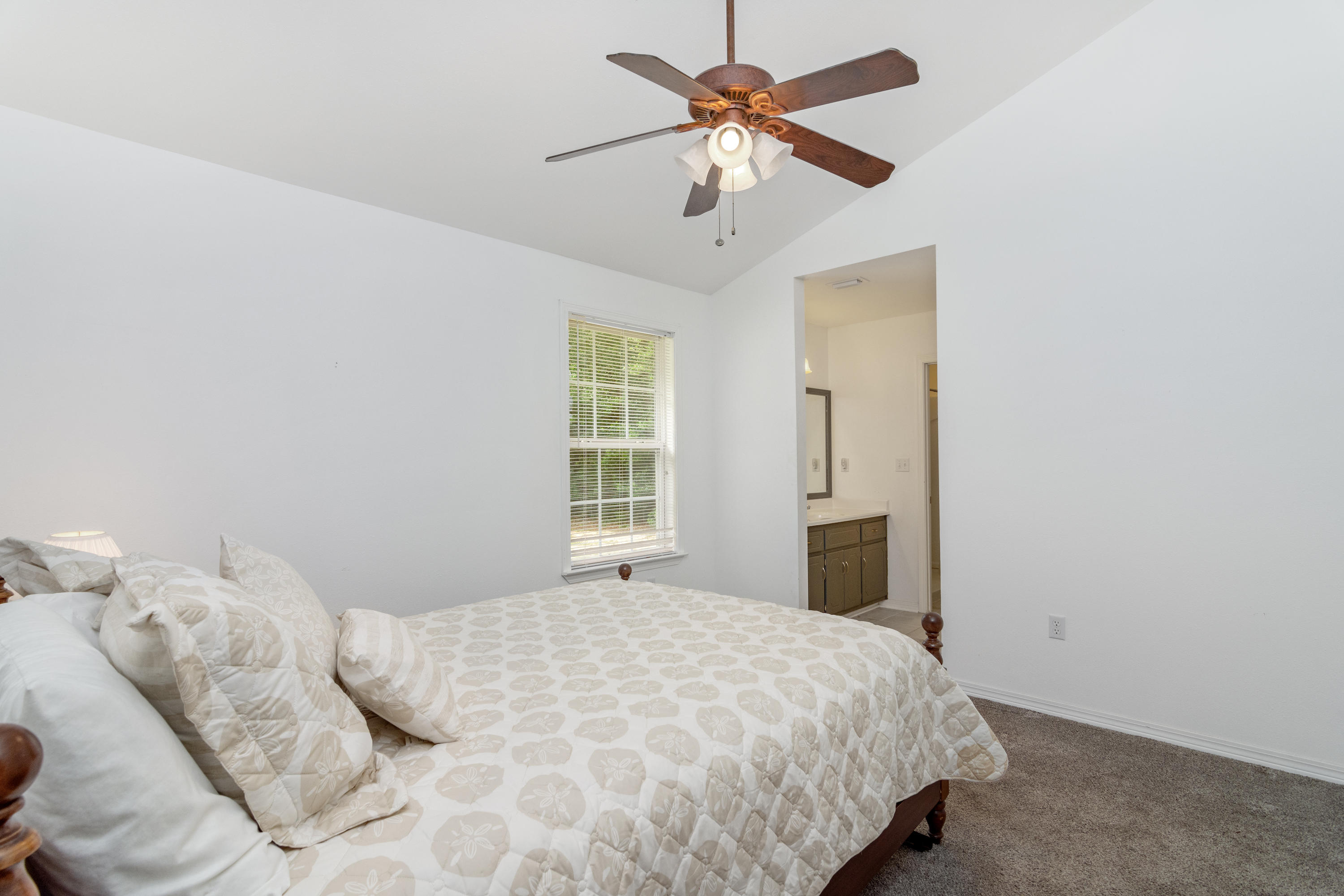 122 Springwood Circle Crestview, FL 32536 - Photo 18 of 27 a bedroom with a large bed and a chandelier