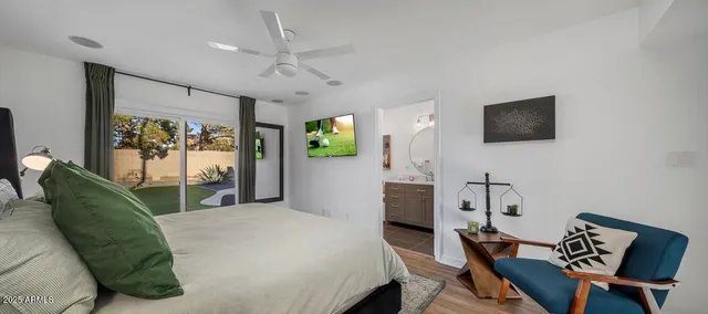 a bedroom with a bed window and a flat screen tv