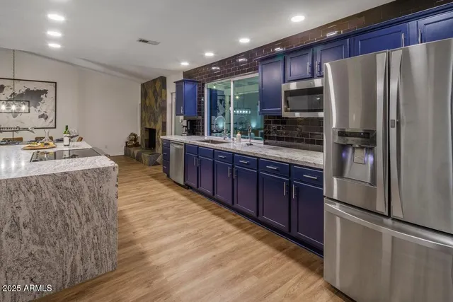 a kitchen with kitchen island a counter top space stainless steel appliances and cabinets