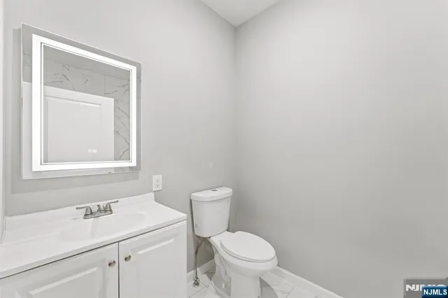 a bathroom with a toilet sink vanity and mirror