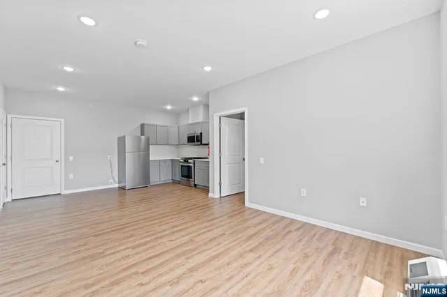 a view of empty room with wooden floor