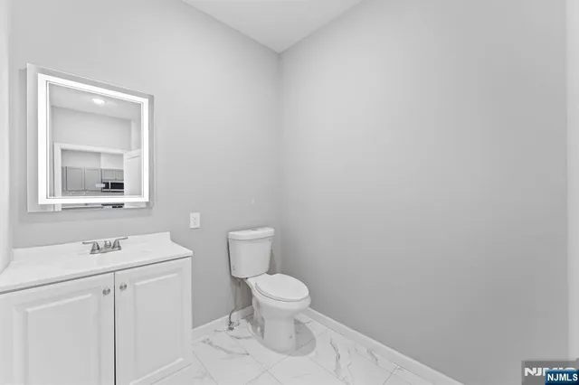 a bathroom with a toilet a sink and mirror