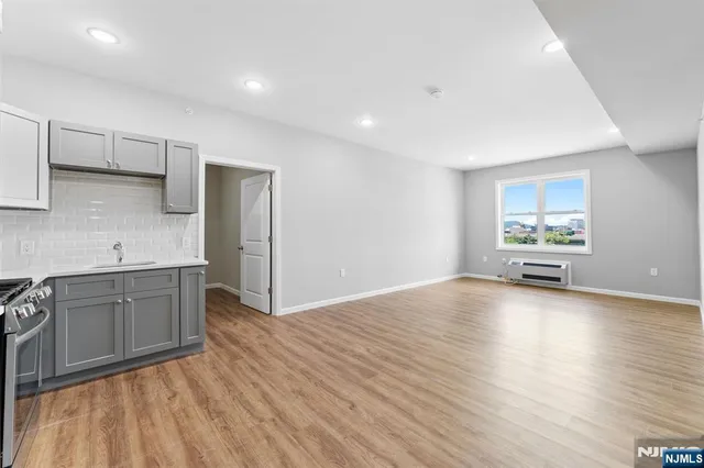 a kitchen with granite countertop a stove a sink and a refrigerator