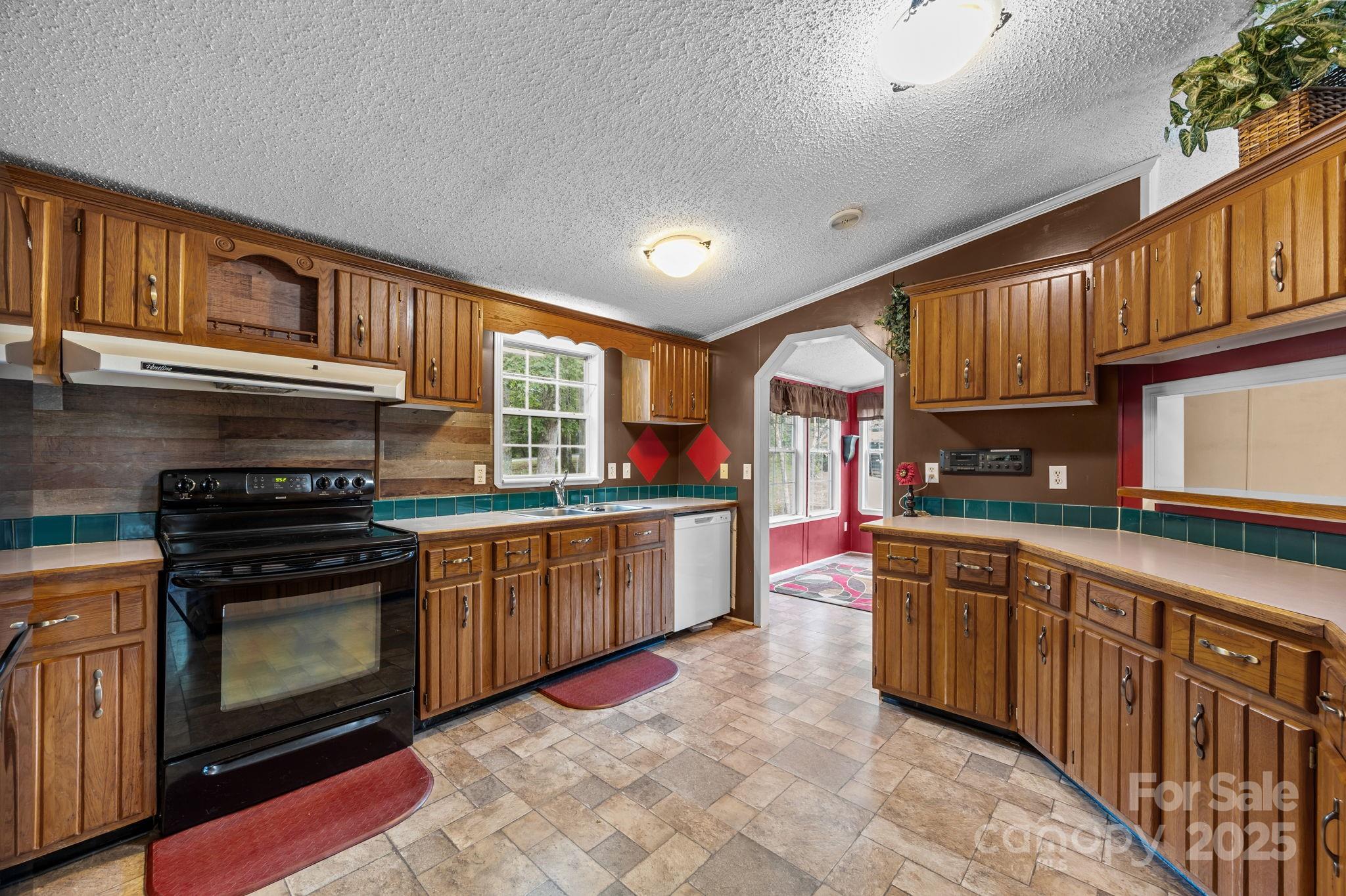 573 Deep Gap Loop Road Flat Rock, NC 28731 - Photo 8 of 20 a kitchen with stainless steel appliances granite countertop a stove sink and cabinets