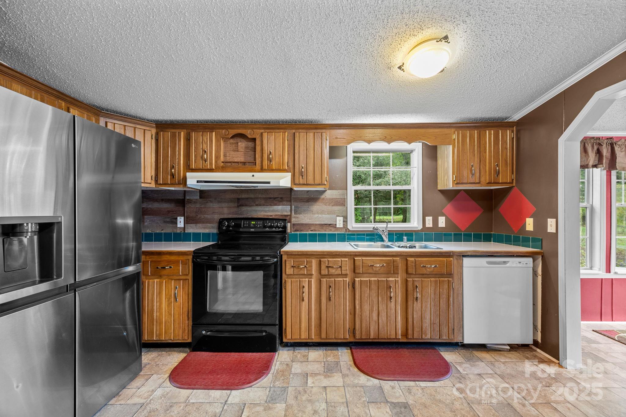 573 Deep Gap Loop Road Flat Rock, NC 28731 - Photo 9 of 20 a kitchen with stainless steel appliances granite countertop a stove a sink and a refrigerator