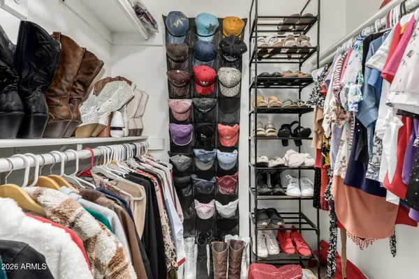 a view of walk in closet with clothes and shoes