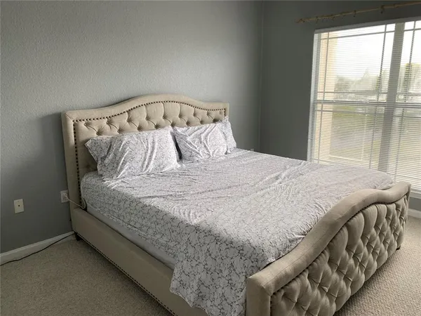 a bed sitting in a bedroom next to a window