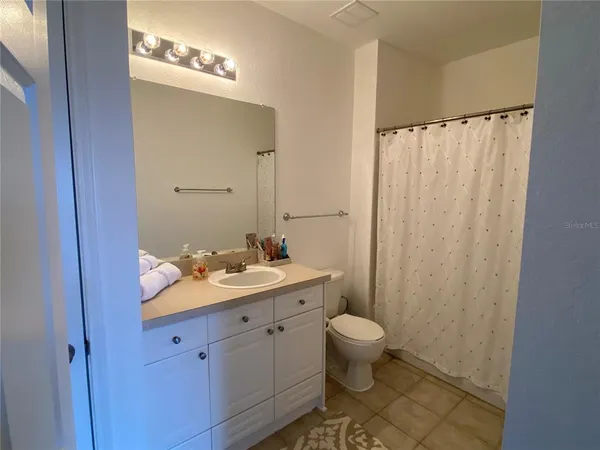 a bathroom with a granite countertop sink a toilet and a mirror