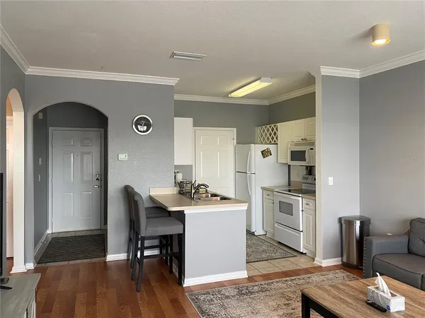 a kitchen with stainless steel appliances granite countertop a stove a refrigerator a kitchen island a dining table and chairs with wooden floor